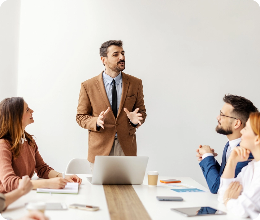 Man presenting to colleagues in a meeting.