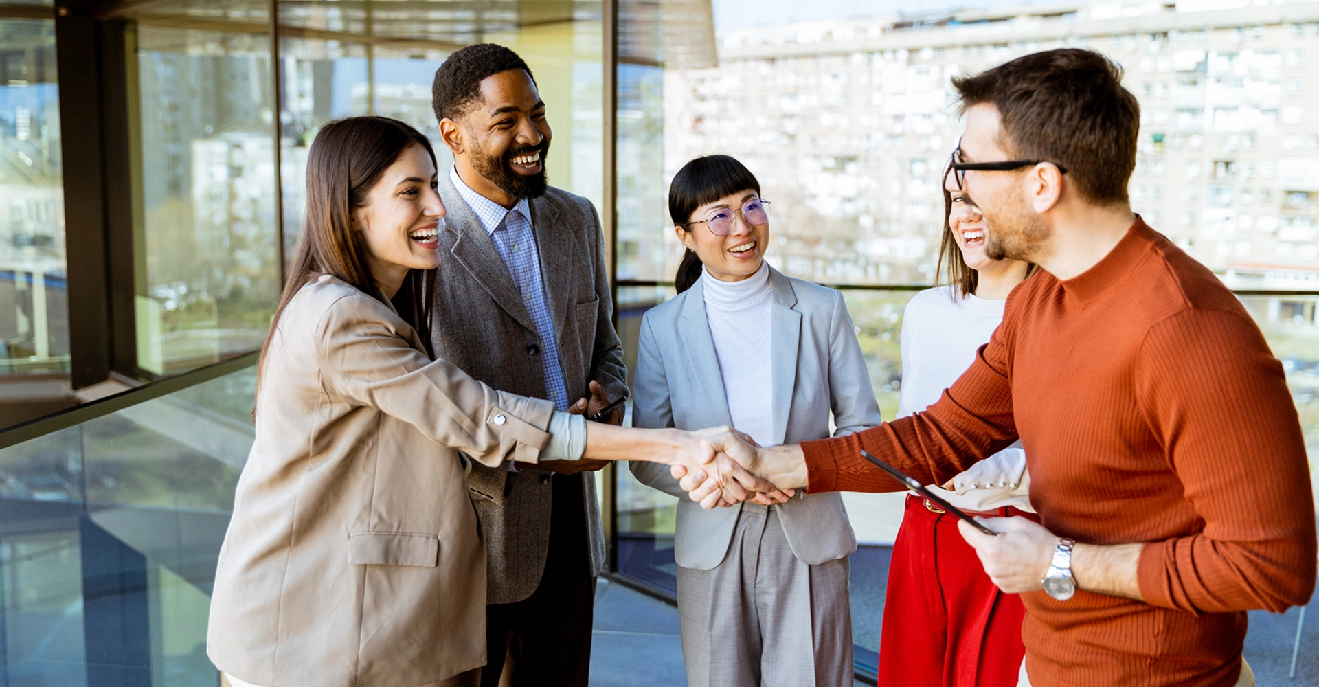 Group of colleagues shaking hands and smiling.